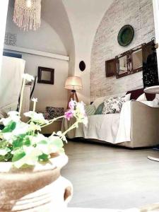 a living room with a bed and a table with a plant at Casa Failla - Das Nest am Meer in Siracusa