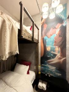 Un dormitorio con una cama y un cuadro en la pared. en e-hostel 心斎橋 207, en Osaka
