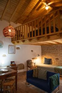 a living room with a blue couch and a bed at Casa do Guardado in Monsanto