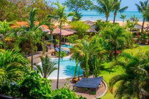 an aerial view of a resort with a pool and palm trees at Pousada Mi Secreto in São Miguel do Gostoso