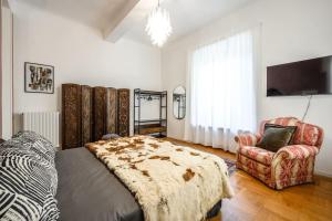 a bedroom with a bed and a chair at Art&Design Boutique Apartment near Ghirlandina in Modena