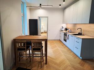 a kitchen with a table and chairs and a refrigerator at Signe Laigu Apartment in Tartu