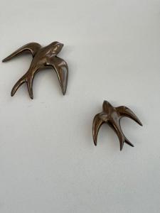 two bronze bird handles sitting on a white surface at Mamma Mia Hotel Boutique - Only Adults in Tossa de Mar