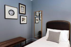1 dormitorio con 1 cama con espejo y cuadros enmarcados en The Maisonette, en Sídney