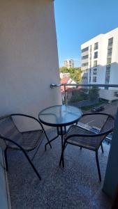 two chairs and a glass table on a balcony at Ultra Central and Spacious with AC and Balcony in Iaşi