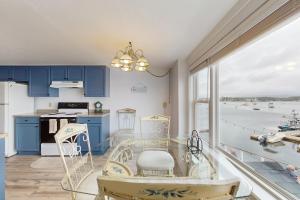 cocina con armarios azules y vistas al agua en Ocean Breeze Condo, en Boothbay Harbor