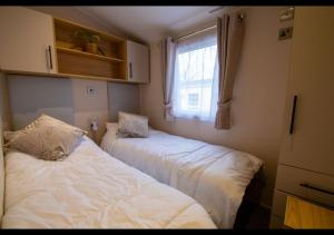 two beds in a small room with a window at 35 Redwood - Beauport Park, Hastings in Hastings +9 photos