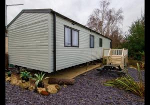 a white tiny house sitting on a wooden deck at 35 Redwood - Beauport Park, Hastings in Hastings