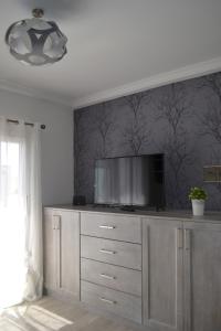 einen Fernseher auf einer Kommode in einem Zimmer in der Unterkunft VV Ático Luxury Vista Mar in Las Palmas de Gran Canaria