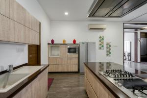 a kitchen with a stove and a refrigerator at Sais lotus villa -Home stay and Event venue in Coimbatore