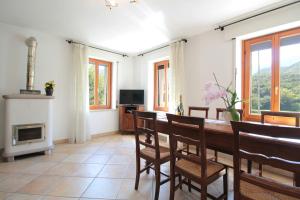a dining room with a table and a fireplace at Apartment With Garden, Del Corlo Lake, Belluno in Primolano