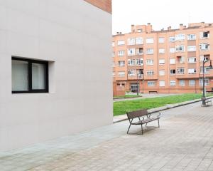 a bench sitting on the side of a building at Apartamento La Gaviota Gijón in Gijón