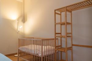 a crib in a room with a book shelf at Apartamento La Gaviota Gijón in Gijón