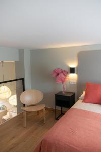 a bedroom with a bed and a chair and a table at Apartamento La Gaviota Gijón in Gijón