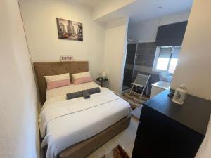 a small bedroom with a bed and a desk at Guesthouse Franco in Porto