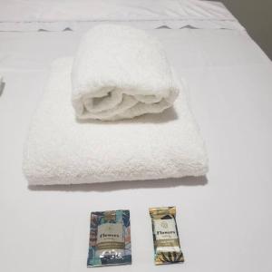 a pile of towels and a package of soap on a bed at Casa Palmeira in Primavera do Leste
