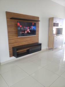 a living room with a flat screen tv on a wall at Casa Palmeira in Primavera do Leste