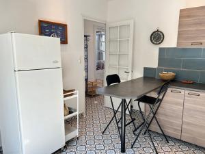 une cuisine avec une table et un réfrigérateur dans l'établissement 1007 Ker Jean Louis - Maison 7p à 300m de la plage, à Pléneuf-Val-André