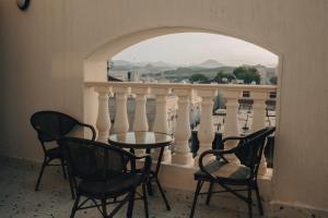 a table and chairs on a balcony with a view at Armada Residence Hotel in Taif