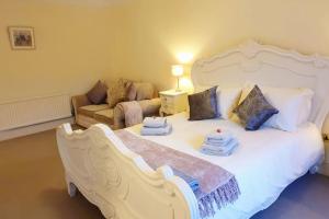 a bedroom with a large white bed and a couch at Period country house set within equestrian centre in Ashford