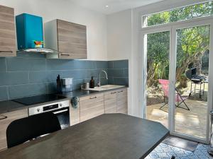 une cuisine avec une table et une grande fenêtre dans l'établissement 1007 Ker Jean Louis - Maison 7p à 300m de la plage, à Pléneuf-Val-André