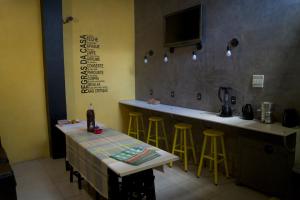 a kitchen with a counter and a bar with stools at Hotel Econômico ao lado do Metrô in São Paulo