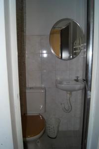 a bathroom with a toilet and a sink and a mirror at Hotel Econômico ao lado do Metrô in São Paulo