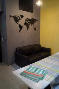 a room with a couch and a world map on the wall at Hotel Econômico ao lado do Metrô in São Paulo