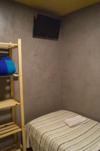 a small room with a bunk bed and a television at Hotel Econômico ao lado do Metrô in São Paulo