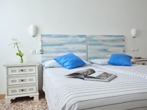 une chambre avec deux lits avec des oreillers bleus et un livre dans l'établissement Riccione Beachouse, à Riccione