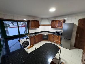 a kitchen with wooden cabinets and a black counter top at Vivienda En El Centro De La Isla 2hab Con Terraza in Valverde