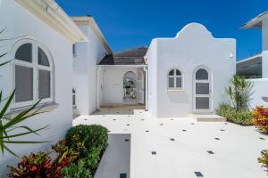 ein weißes Haus mit einem Weg, der zur Eingangstür führt in der Unterkunft Royal Westmoreland - Cassia Heights 14 townhouse in Saint James