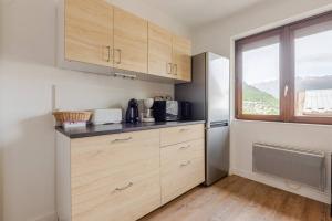 una cucina con armadi in legno e una finestra di Appartement au cœur de la Vallée de la Maurienne a Saint-Julien-Mont-denis