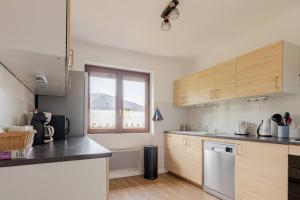 una cucina con armadi in legno e una finestra di Appartement au cœur de la Vallée de la Maurienne a Saint-Julien-Mont-denis