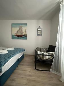 a bedroom with a bed and a chair and a boat at Retro room-Otok Vis in Podstražje
