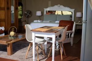 a bedroom with a table and chairs and a bed at Oakron at Patatsfontein Stay in Montagu +18 photos