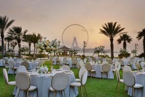a wedding reception with white tables and chairs and the wheel at The Ritz-Carlton, Dubai in Dubai +156 photos
