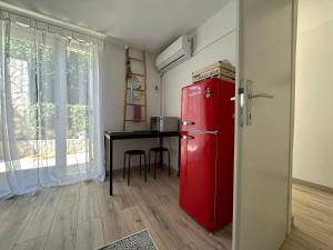 a red refrigerator in a room with a table at Retro room-Otok Vis in Podstražje