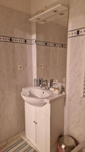 a bathroom with a white sink and a mirror at Résidence Royal Plaza Menton in Menton +15 photos