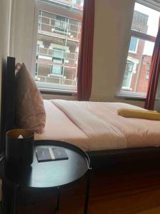 a room with a bed and a table and a window at The Rotterdam Suite in Rotterdam