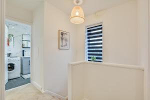 a hallway with a laundry room and a washer and dryer at Warm & Cosy, Pet-friendly Home in Worsley +68 photos