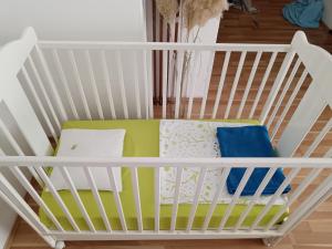 een wit kinderbedje met kussens in een kamer bij Fran in Novi Zagreb