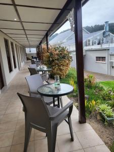 a patio with tables and chairs on a balcony at Lake Pleasant Hotel in Sedgefield +7 photos