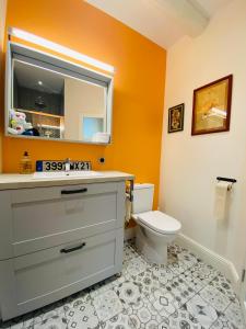 a bathroom with a toilet and a sink and a mirror at Le nid des Petits à 15 min de Bordeaux in Sainte-Eulalie +18 photos