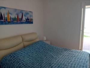 a bedroom with a bed and a painting of sailboats at About Capri in Anacapri