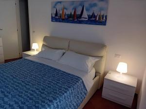 a bedroom with a bed with a blue bedspread and two lamps at About Capri in Anacapri