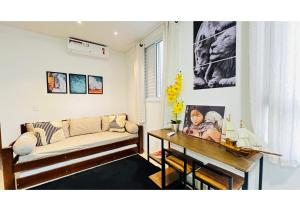 una sala de estar con un sofá y una mesa en Portal das Palmeiras 2, en Ubatuba