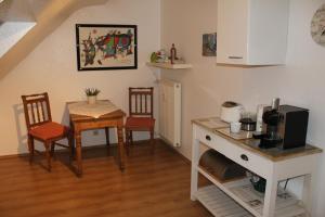 eine Küche und ein Esszimmer mit einem Tisch und einer Mikrowelle in der Unterkunft Appartementwohnung Antonia in Düsseldorf