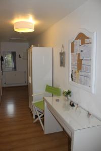 einen weißen Schreibtisch mit einem grünen Stuhl in einem Zimmer in der Unterkunft Appartementwohnung Antonia in Düsseldorf + 26 Fotos