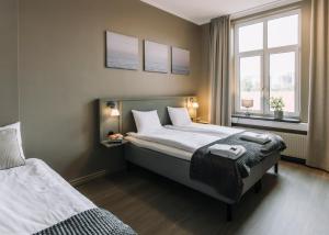 una camera da letto con due letti e due finestre di My Hostel Lidköping a Lidköping